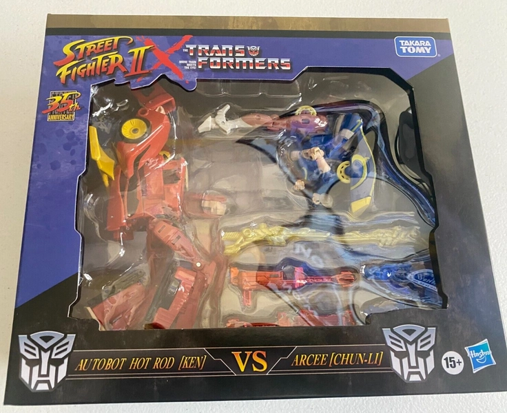 Transformers Collaborative Street Fighter II Mash-Up Hot Rod Ken vs. Arcee Ch...