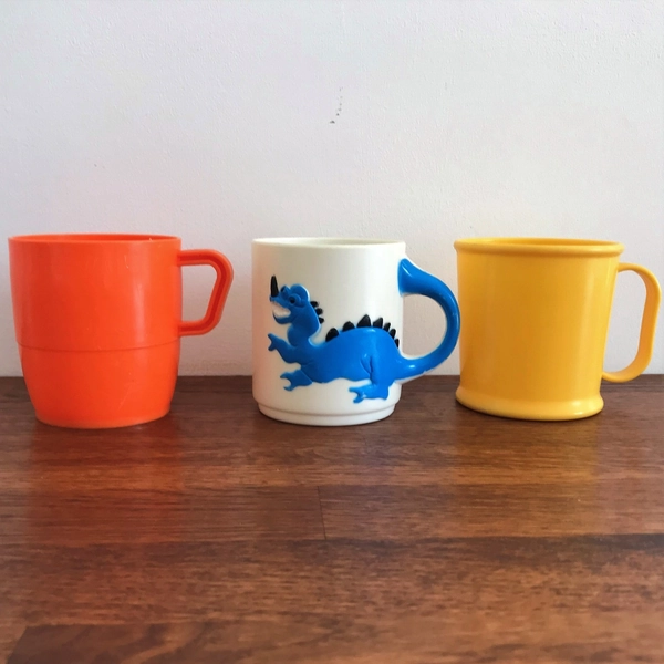 3 vintage 1980's child's plastic mugs – yellow, orange and dragon design.