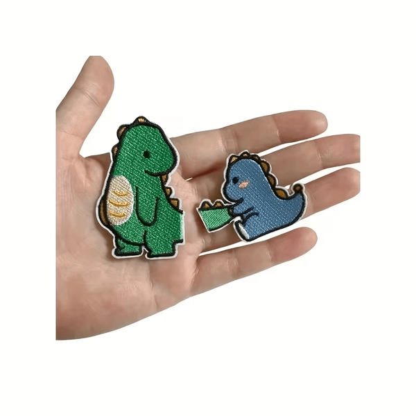 A Set of Two Adorable Dinosaur-Themed Embroidered Patches That Are Hot Pressed, Designed As Seamless Fabric Stickers. Perfect for Clothing Repairs, They Work Well on Jeans, Sweaters, And Jackets, Making It Easy to Add Decorative Touches to Clothes
