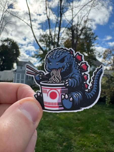 Cute godzilla kaiju eating ramen sticker - unique vinyl decal
