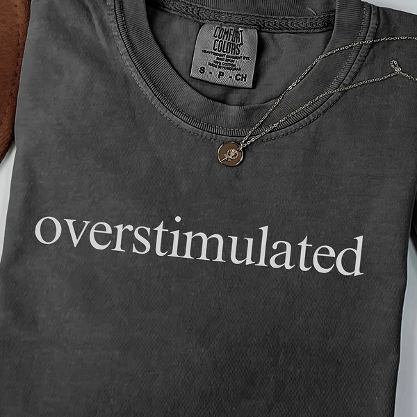 Women's Overstimulated Graphic T-Shirt - Light Beige Soft Round Neck Short Sleeve Tee with Bold White Lettering, Casual Comfortable Casual Attire, All-Season Versatile Top for Lounge & Outfits, Machine Washable Smooth Texture (No Wrinkles) - Funny Statement Tee for Women, Relaxed Attire, Everyday Outfit, Short Sleeve Shirt, Soft Fabric, Breathable Material, Printed Shirt, Adults, Trendy Wear