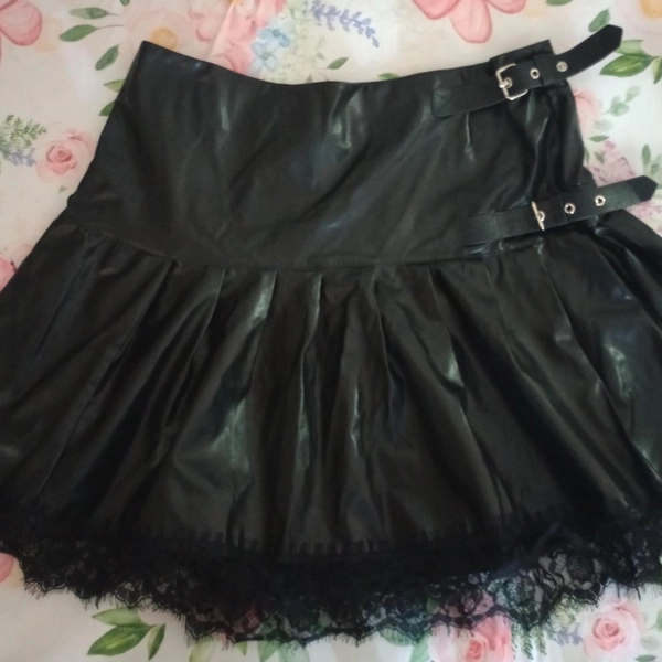 Faux leather skirt with waist buckles and lace trim.