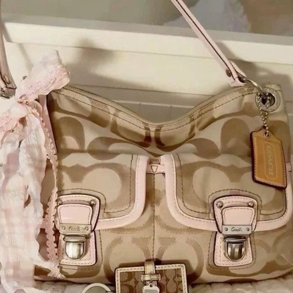 Coach Poppy hobo shoulder bag in a tan signature canvas with light pink trim.