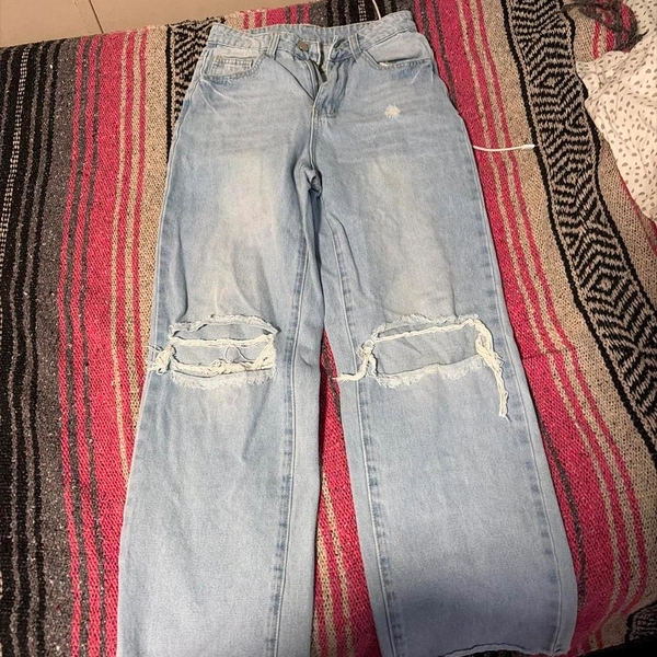 Light wash distressed jeans with ripped knees...