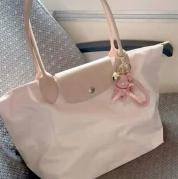 a pink Longchamp Le Pliage tote bag