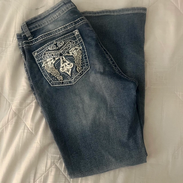 light wash blue flared jeans with angel wings design...