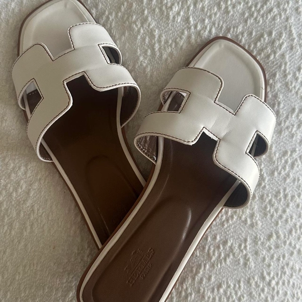 White leather sandals with brown accents...