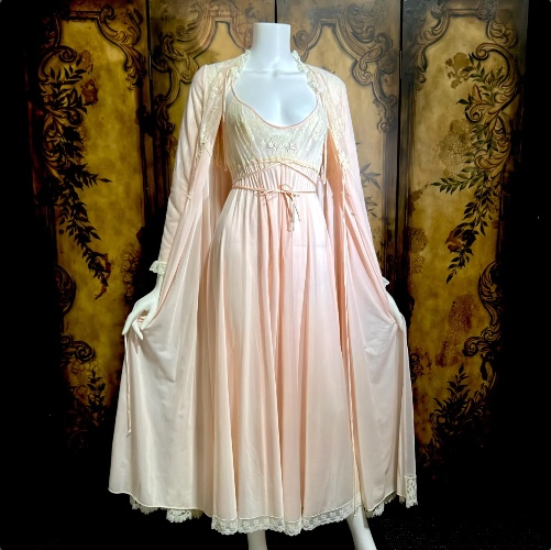 May include: A vintage-style, pale pink nightgown and matching robe set. The nightgown features a lace-trimmed bodice and hem, with a delicate tie at the waist. The robe has long sleeves and a lace collar, creating a romantic and elegant look.  May include: A vintage-style, pale pink nightgown and matching robe set. The nightgown features a lace-trimmed bodice and hem, with a delicate tie at the waist. The robe has long sleeves and a lace collar, creating a romantic and elegant look. May include: A vintage-style, pale pink nightgown and matching robe set displayed on a mannequin. The nightgown features a lace bodice and a flowing skirt. The robe has long sleeves and lace trim. The set is made of a soft, sheer fabric. May include: A light pink lingerie set on a mannequin. The set includes a slip dress with a lace bodice and butterfly embellishments, and a matching robe with lace trim. The dress has a ribbon tie at the waist. May include: A light pink nightgown with delicate spaghetti straps and a lace bodice. The bodice features two small butterfly embellishments. A satin ribbon cinches the waist, and the skirt flows to the floor. May include: A pale pink nightgown on a mannequin. The bodice is cream-colored lace with delicate butterfly embellishments. The gown has spaghetti straps and a cinched waist with a matching tie. The skirt flows to the floor. May include: Pale pink vintage nightgown on a mannequin. The nightgown features a lace-trimmed bodice and hem, with spaghetti straps and a drawstring waist. The fabric appears to be a soft, flowing material. May include: A vintage pale pink nightgown with long sleeves and a floor-length skirt. The bodice features a cream-colored lace insert and a drawstring neckline. The sleeves and hem are trimmed with delicate lace. A classic, elegant sleepwear piece. May include: A light pink nightgown on a mannequin. The nightgown features spaghetti straps, a lace bodice, and a drawstring waist. The hemline is trimmed with white lace. The nightgown is floor-length. May include: A vintage peach-colored lingerie set on a mannequin. The set includes a floor-length nightgown with a lace bodice and a matching robe with lace trim. The nightgown has a tie at the waist. The robe has long sleeves. May include: A vintage-style, pale pink nightgown on a mannequin. The gown features a delicate lace bodice with thin straps and a flowing skirt. A matching ribbon belt cinches the waist. The nightgown is a soft, romantic piece. May include: A vintage pale pink nightgown and robe set. The nightgown features a lace-trimmed bodice and a flowing skirt. The robe has long sleeves and a matching lace trim. The set is displayed on a mannequin. May include: A vintage-style, pale pink nightgown with long sleeves and a flowing skirt. The back features a cream-colored lace panel and a high, ruffled collar. The sleeves end with delicate lace cuffs, creating an elegant, romantic look. May include: A vintage pale pink nightgown with long sleeves and a high neckline. The bodice features a cream-colored lace panel, and the sleeves and hem are trimmed with lace. The gown is displayed on a mannequin against a dark background. May include: Close-up of two white fabric tags with gold lettering. The top tag reads "Claire Sandra by Lucie Ann Beverly Hills." The bottom tag details washing instructions: "Hand wash in cold water preferably or machine gentle cycle. Rinse cold towel." May include: A vintage, pale pink nightgown with long sleeves and a flowing, sheer overlay. The gown features a lace trim at the hem and cuffs, and a delicate tie closure at the bodice. The overlay is a light, airy fabric. Report this item to Etsy 13 views in the last 24 hours Price:$249.00 Vintage nightgown robe set, LUCIE ANN Claire Sandra peignoir set, 1960s pink long lingerie set